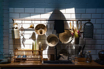 vintage kitchen utensils on wall above sink. retro kitchenware.
