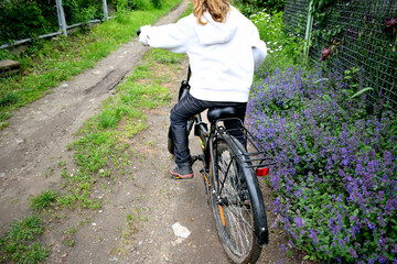 girl rides a bicycle on a rural road