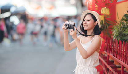 Portrait of young beautiful asian woman taking photo with digital camera outdoors with happiness, copy space.