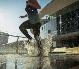young runner splashing in the water while training