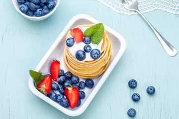 Pancakes with fruit and cream cheese. Fresh blueberries and mint. Breakfast