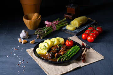 dumplings with beef goulash and green asparagus