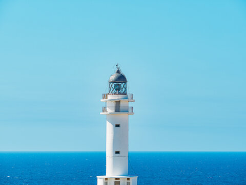 Vistas de faro blanco con playa de Formentera de fondo