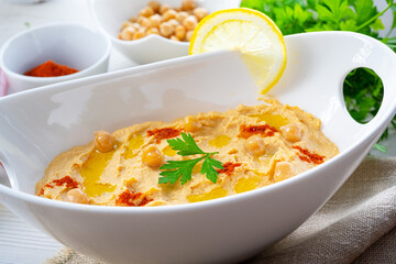 hummus paste with lemon and chilli on white background