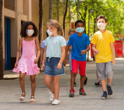Group of positive children in masks walking together