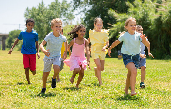 Cheerful kids are jogging together in the park