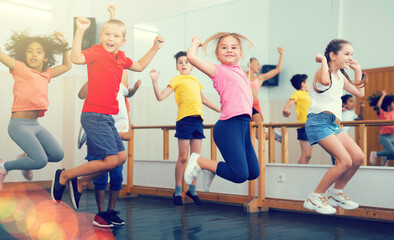 Fototapeta na wymiar Boys and girls jumping in dance studio