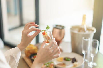 Woman hand holds different snacks and appetizers food at a cocktail party.