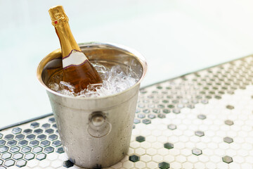 Champagne bottle in ice bucket and two glasses near bubble pool © marchsirawit