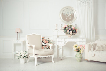 luxury clean bright white interior. a spacious room with sunlight and flowers in vases and royal chic furniture. 