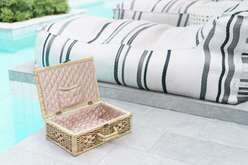 wicker suitcase near the pool.