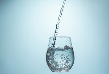 Water Pouring Into a Glass on a blue gradient