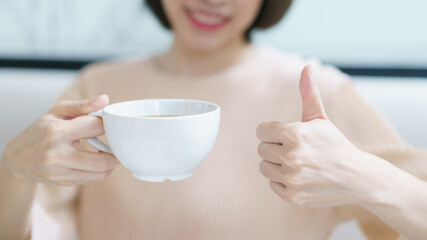 Good coffee. Woman drinking tea or coffee. White cup of hot beverage in the morning.
