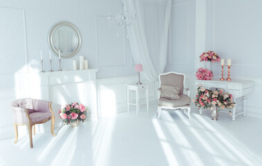 luxury clean bright white interior. a spacious room with sunlight and flowers in vases and royal chic furniture. 