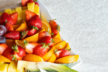 fresh raw fruit plate strawberry orange and pineapple on a white table cloth background texture surface advertising food concept picture with empty copy space for your text