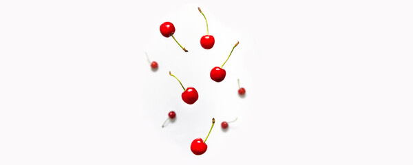 Ripe cherry berry with green leaves levitating on white background. Berry summer background. Flat lay, top view, copy space