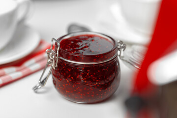 Glass jar of fruit jam on wooden kitchen table