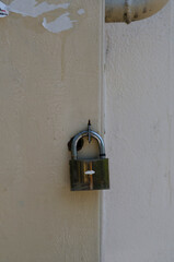 Padlock on the door. Iron door. Cracked paint.