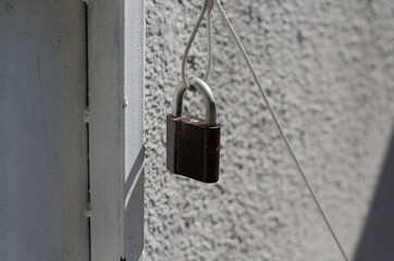 Padlock on the door. Metal mesh, wicket.
