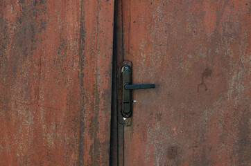 Iron gate. Steel door. A lock on the door. Rust.
