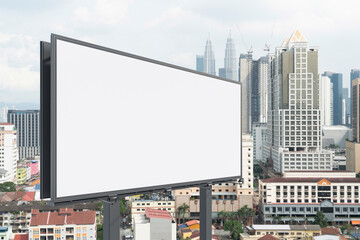 Blank white road billboard with KL cityscape background at day time. Street advertising poster, mock up, 3D rendering. Side view. The concept of marketing communication to promote or sell idea.