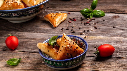 Uzbek national dish samosa. Wooden board with delicious samosas on table. Samosa, samsa meat stuffed pies, oriental style