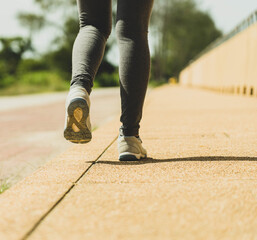 Runner woman feet running on 
Roadside footpath