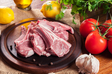 Raw fresh lamb chops on wooden cutting board