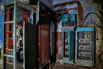 Fototapeta na wymiar Broken electrical switchgear cabinets with control panels in abandoned building