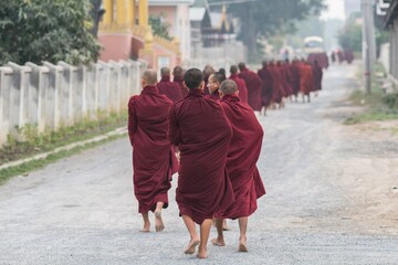 Monks walk round bare foot early in the morning collecting alms in Myanmar Burma