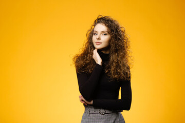 Pretty girl with curly hair on yellow background