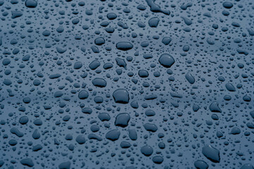 water droplets that stick on the surface of a dark black glass