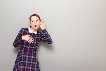 Portrait of curious girl placing hand near ear and eavesdropping
