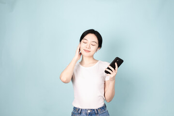 Fototapeta premium A Young Chinese Woman In Front of Blue Background