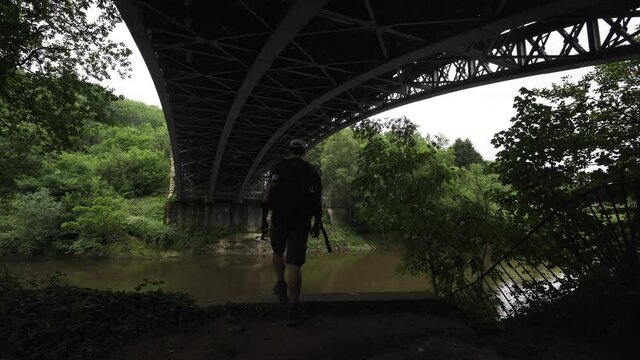 A man walking below a river bridge in the Severn Valley