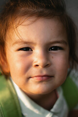 Toddler girl close up portrait in sunshine light. Summer day. Back to school