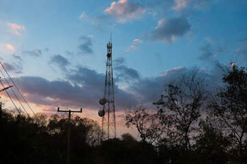 Mobile phone communication antenna tower with satellite dish.