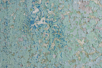 Peeling paint on the wall. Old concrete wall with cracked flaking paint. Weathered rough painted surface with patterns of cracks and peeling. High resolution texture for background and design. Closeup