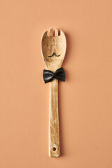 Cartoon man with a mustache from farfalle pasta and wooden spoon, conceptual photography for food...