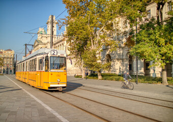 Yellow tram moving along city road in Budapest, Hungary.