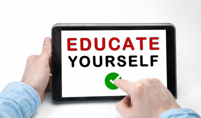Male hands holding tablet pc with text EDUCATE YOURSELF on white background