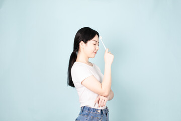 A Young Chinese Woman In Front of Blue Background