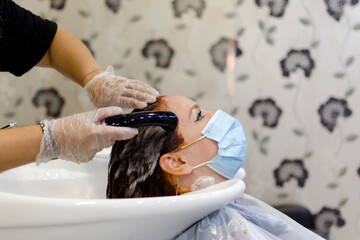 Mujer joven lavándose el pelo en una peluquería