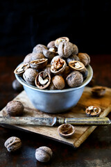 Walnuts in a bowl on a dark background. Unpeeled walnuts. Inshell walnuts.