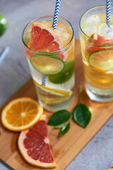 Health care, fitness, healthy nutrition diet concept. Fresh cool homemade citrus infused detox water with grapefruit, orange, lemon and lime and ice in a jug and glasses for spring summer days.