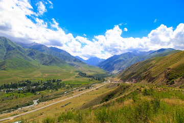 View of the gorge in the mountains. The village and the road. Summer landscape. Kyrgyzstan Issyk-ata gorge.
