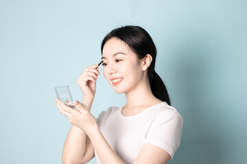 A Young Chinese woman in front of a blue background