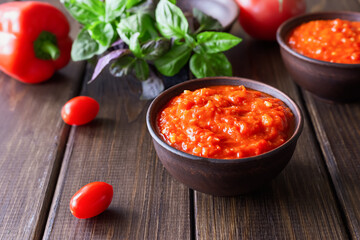 Balkan sauce ajvar and ingredients for its preparation on a wooden table. Serbian traditional food