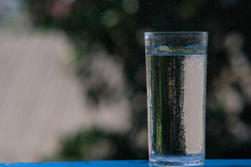 glass of water on wood table background and pouring drinking water
