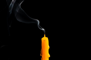 Candle out of fire and white smoke on black background, extinguished